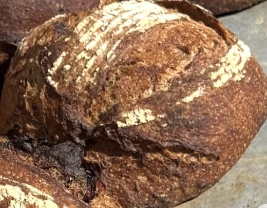Hogaza de pan de masa madre con corteza dorada y greñado marcado